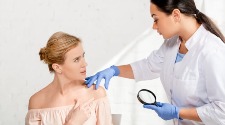 female doctor examining female patient's shoulder