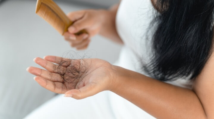 woman looking at hair loss