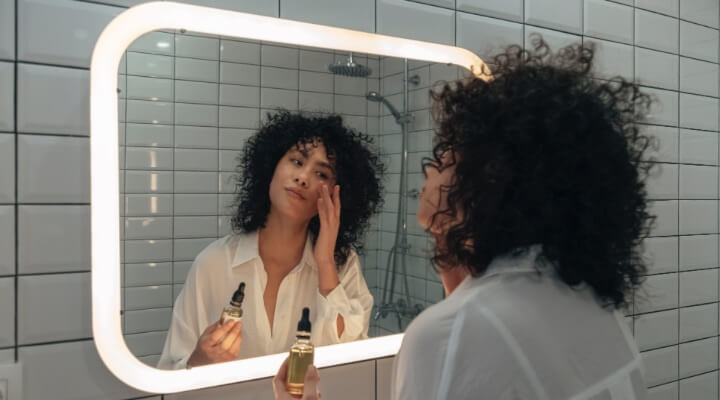 woman doing skincare in mirror
